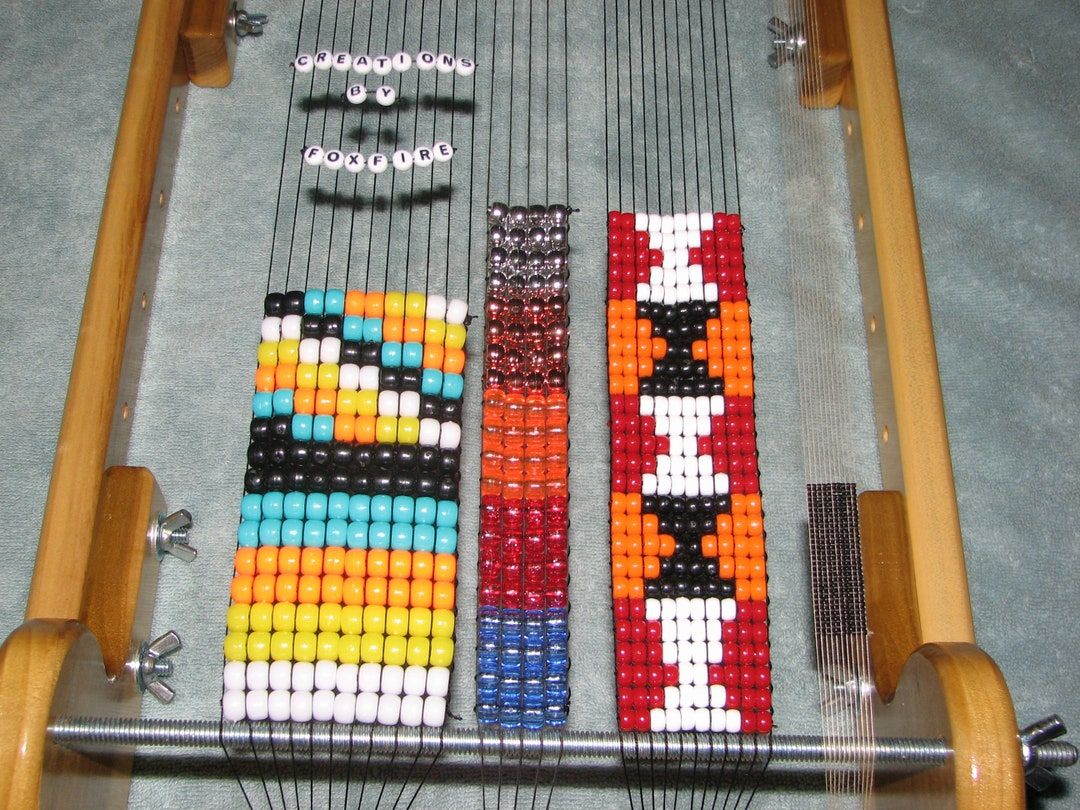 Three strips of loomed beadwork in progress on a light wood Foxfire loom
