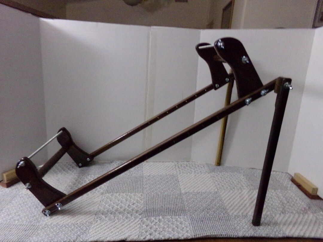 A dark walnut-stained Gerdan-style loom tilted up on its stand